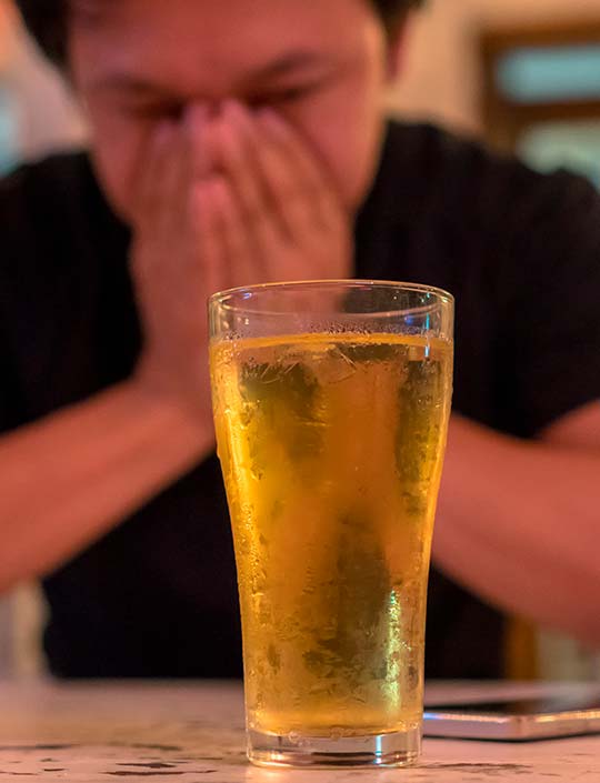 Мужчина сидит с бокалом пива